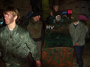 Carnival costumes: A group of guys and girls dressed up in army gear and rolling around a shopping-cart-tank.