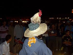 Back at the main square. Not permanent lighting exists in this square, so storytellers, dancers, musicians, etc. bring their own oil lanterns. Dozens of individual circles develop, each with a unique private show. Very cool. 

Oh yeah - this guy was playing guitar with a live chicken on his head.