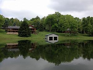 View of the landlord's cabin, the boat dock (and our cabin behind the trees on the right) from the lake
