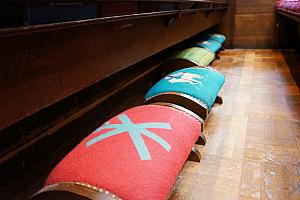 Inside Trinity Church, admiring the unique individual, fabric-wrapped kneelers in each pew.