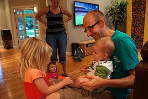 Jay taking a turn at playing with Cooper, while Cardin and Claire look on.