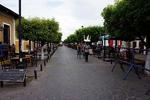 Main tourist street in Granada; worker carrying a table on his head