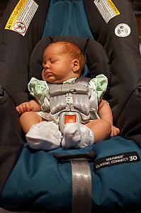 Sleeping soundly in her car seat.