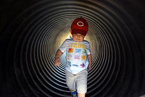 At the pumpkin patch, Cooper walking through a tunnel.