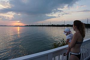 Capri and her mom watching the sun as it sets behind the clouds.