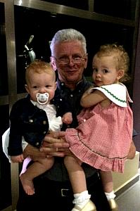 Grandpa at dinner holding his granddaughters!