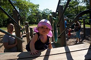 Kenley climbing through a playground