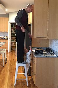 Capri and Daddy cleaning out a kitchen cabinet