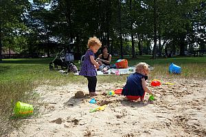 Kenley and Capri playing in the sand while the adults play some volleyball.