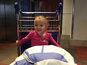 Capri riding on her throne -
 the luggage cart - through all of Philadelphia International Airport. 

That cart was a lifesaver - we pushed it through five terminals, and it carried Capri, two backpacks, a stroller, and a carry-on suitcase. Would have been an adventure!