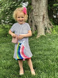 Showing off her rainbow airplane dress.