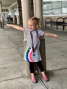 Capri excited to be at CVG airport, wearing her rainbow airplane dress and her flying piglet medal :)